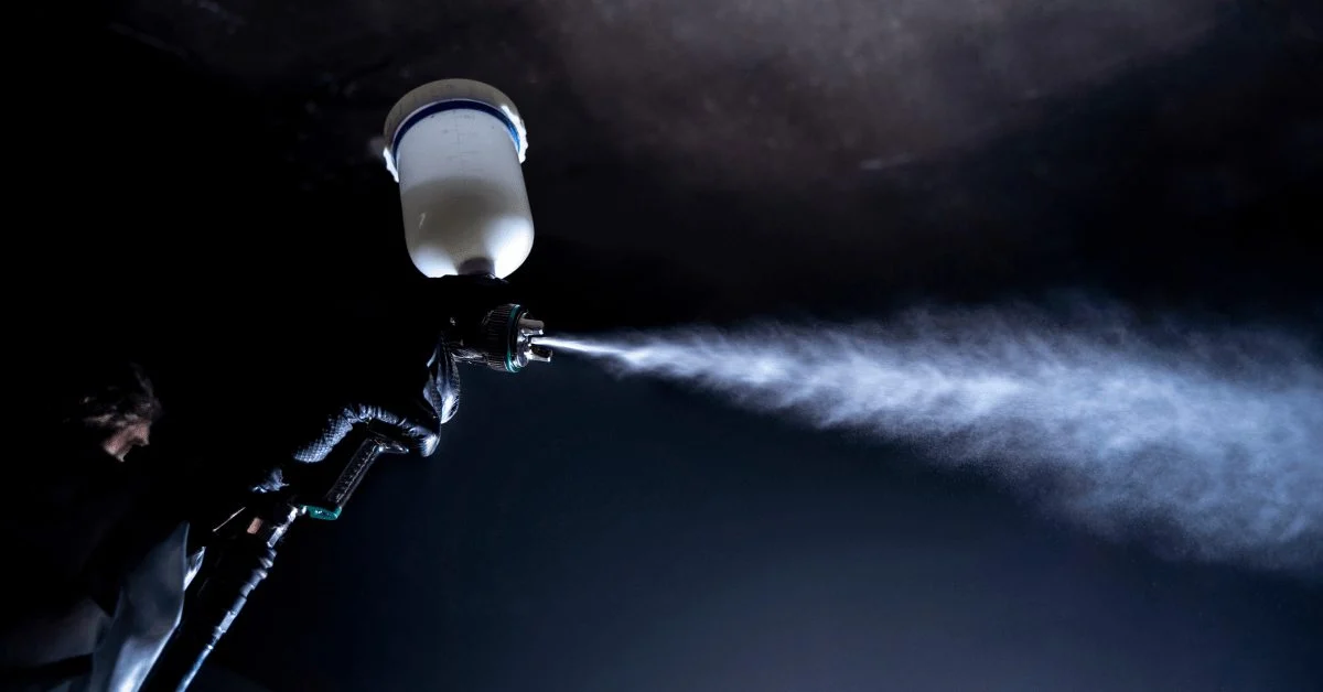 Spray gun releasing a fine mist in the dark