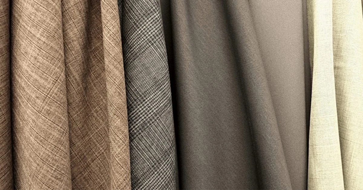 Hanging fabric swatches in grey, beige and brown tones