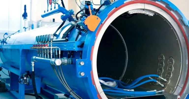 Autoclave industriel ouvert, avec ses canalisations bleues